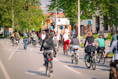 Bisiklet süren, şehirde bisiklete binen, kalabalık içinde araba kullanan bir grup genç, trafikteki ve kentsel çevredeki bisikletçiler için tehlikelere dikkat çekmeye çalışıyor.. 