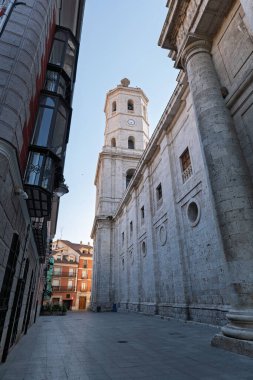 Valladolid, İspanya. Güneşli bir günde tarihi bir cadde boyunca uzanan eski bir binanın manzarası..