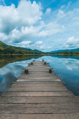 Dağ manzaralı göldeki ahşap iskele manzarası. Sabah erken saatlerde.