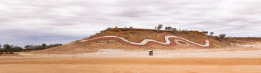 Indigenous artwork of a dreamtime serpent on a hill at Betoota, south-west of Longreach in far-west Queensland public artworks to tell women's Dreamtime stories of the Mithika, Wangkamadla and Wangkangurru people clipart