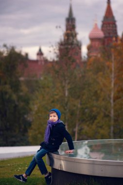 Sonbahar şehrinin arka planında sevimli bir çocuğun portresi.