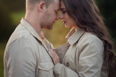 Birkaç genç aşık parkta sonbahar yürüyüşünde birbirlerine sarılırlar.