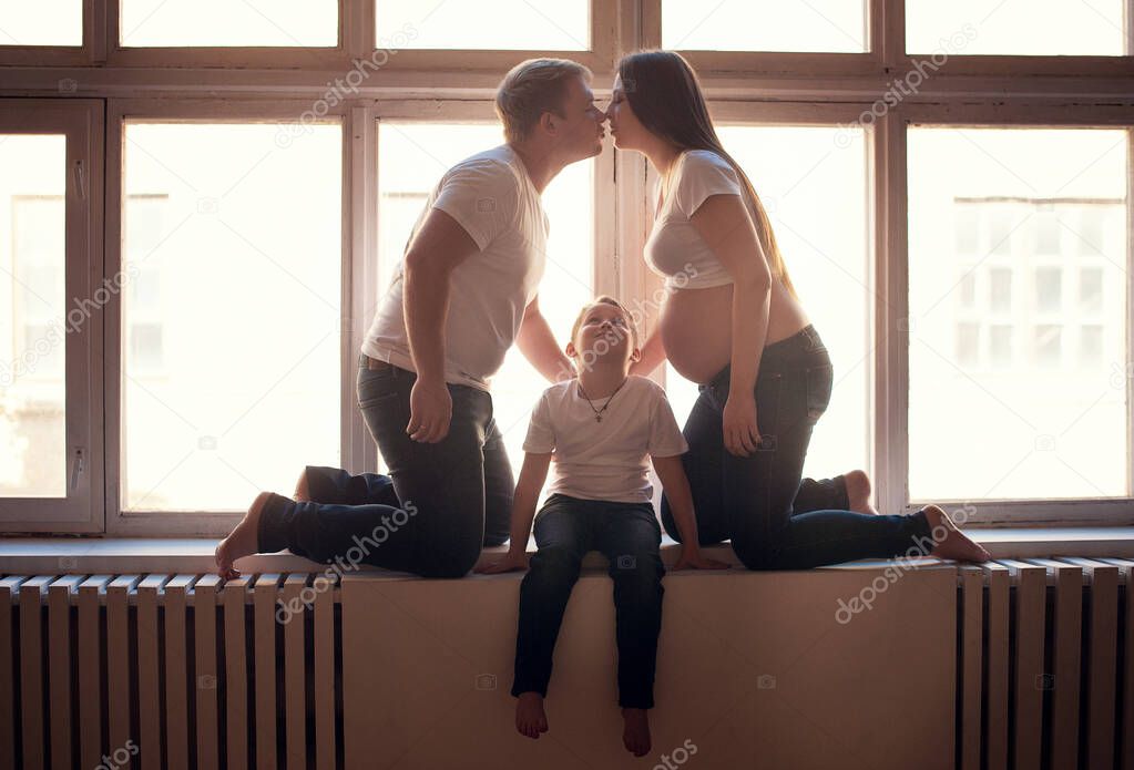Young pregnant woman with her family at home