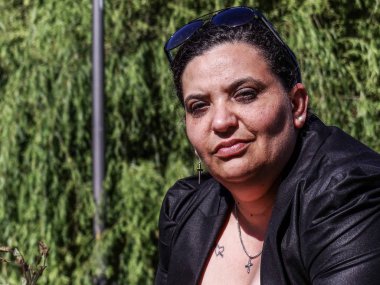 Kadın parkta korkuluk üzerinde dinlenme