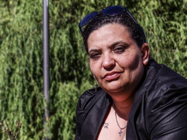 Kadın parkta korkuluk üzerinde dinlenme