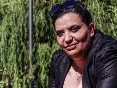 Kadın parkta korkuluk üzerinde dinlenme