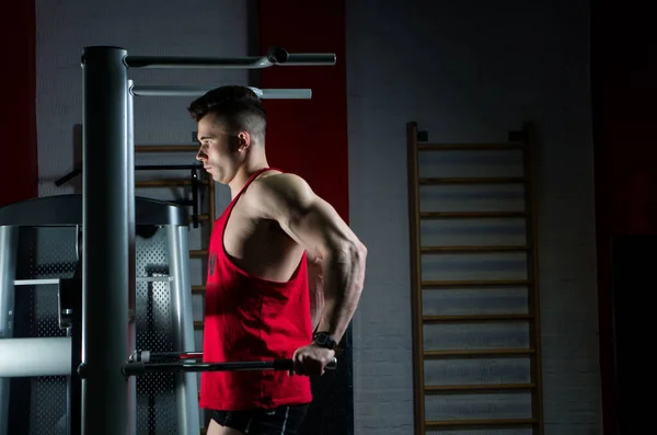 The man in the red shirt is at the gym horizontal