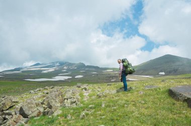 Bir sırt çantası ile turist alagöz, Ermenistan tepesine yükselir