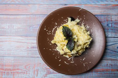 Şu ahşap arka plan üstten görünüm üzerinde kahverengi bir tabak makarna carbonara