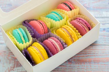 Ahşap arka plan üzerinde beyaz Ambalaj kutusundaki macaroons