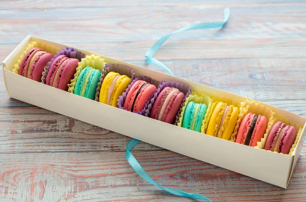 Macaroons in a white packing box on a wooden background