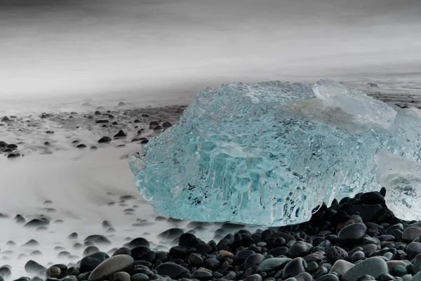 Голубая ледяная глыба, лежащая на брусчатом пляже возле Йокулсарлона — стоковое фото