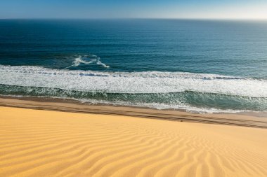 Walvis Körfezi yakınlarındaki Atlantik okyanusunda çöl kumulları bitiyor.