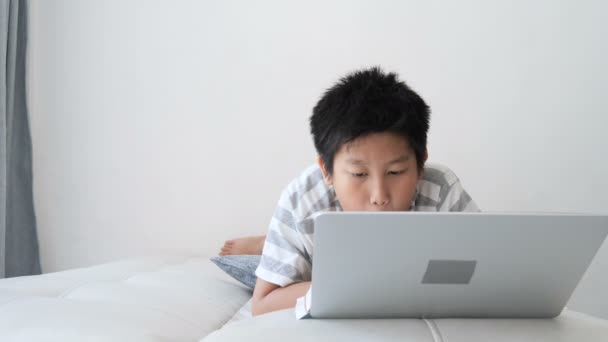 Asiatische Preteen Junge Liegend Auf Bett Und Mit Laptop Hause — Stockvideo