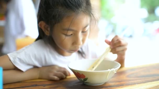 現地のレストランでおいしい麺を食べるアジアの女の子 — ストック動画