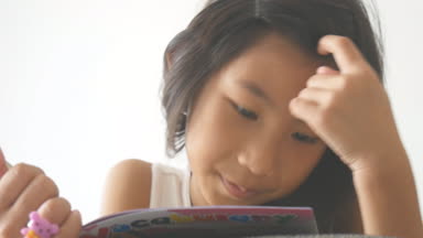 Asyalı kız kitap okuma ve gülümseyen koltukta yalan