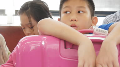 Asyalı çocuk büyük pembe Bagaj Japonya, seyahat kavramı ve el atış trende otururken holding