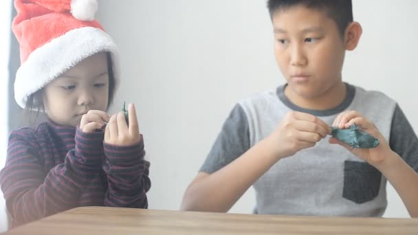 Маленькая Азиатка Санта Играть Тестом Моделирования Глины Своим Братом — стоковое видео