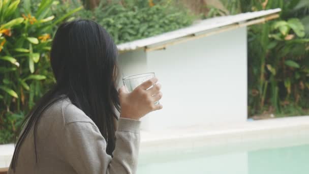 Asiatisk Tjej Dricka Ett Glas Vatten Koppla Poolterrassen — Stockvideo