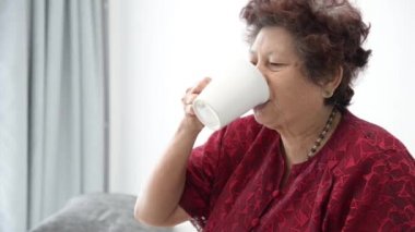Asyalı kadın kıdemli evde bir bardak su içme
