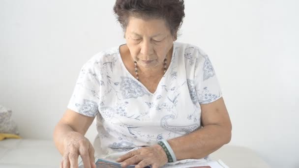 Asiática Senior Mujer Leyendo Libro Casa — Vídeo de stock