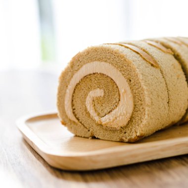 Kahve rulo pasta üzerinde ahşap masa.