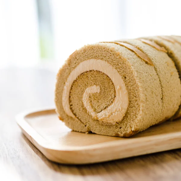 Kahve rulo pasta üzerinde ahşap masa.