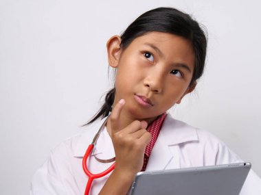 Tablet tutarak ve fikri için ararken Doktor üniformalı mutlu Asyalı kız.