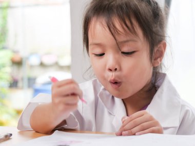 Evde ödev yapmak mutlu Asyalı kız.