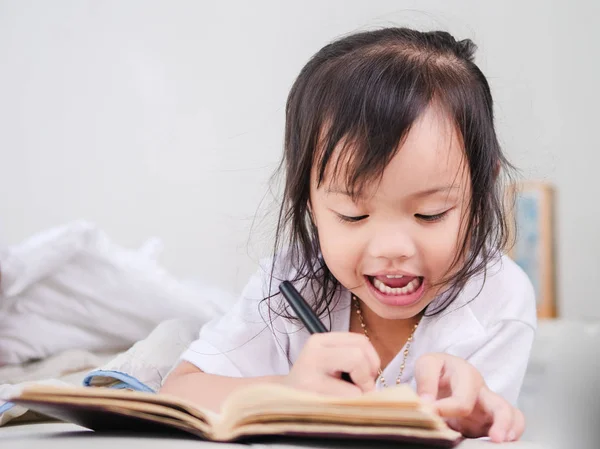 Happy Asian Girl Doing Homework Lying Bed — Stock Photo, Image