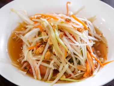 Beyaz çanak üzerinde papaya salatası.