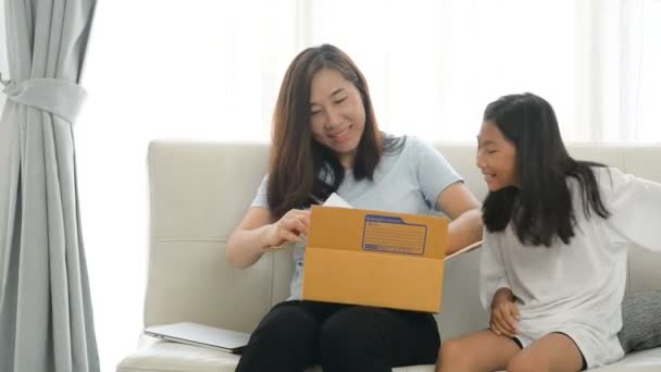 エキサイティングなアジアの母と娘の茶色の小包ボックスを開くは インターネットから購入した後に送信されました — ストック動画