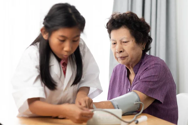Senior Vrouw Met Bloeddruk Testen Jonge Arts Met Haar Grootmoeder — Stockfoto