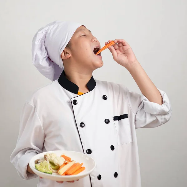 Азиатский Мальчик Подросток Форме Шеф Повара Ест Морковь Держит Овощи — стоковое фото