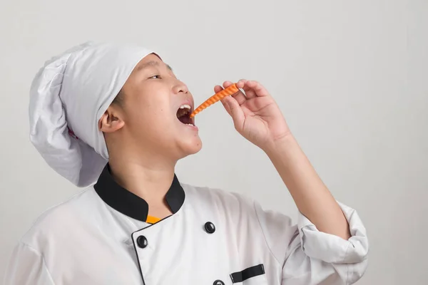 Азиатский Мальчик Подросток Форме Шеф Повара Ест Морковь Держит Овощи — стоковое фото