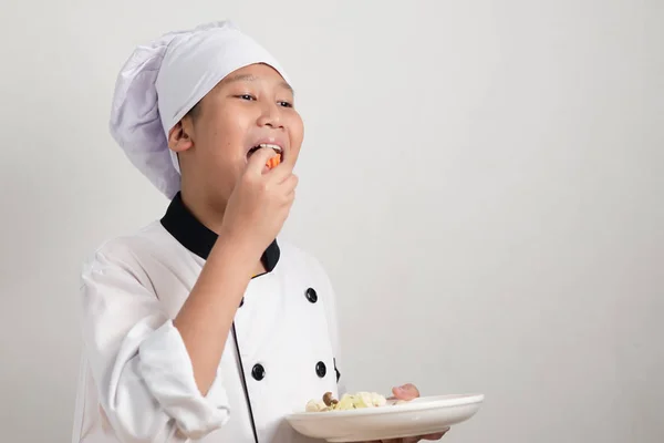 Preteen Aziatisch Uniform Van Chef Kok Eten Van Wortel Fruit — Stockfoto