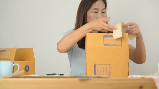 アジアの女性包装茶色宅配ボックス配信する前に アジア女性在宅勤務 事業が起動オンライン ビジネス 中小企業 配信プロジェクトのためのオンライン ビジネスや中小企業を持つ女性 — ストック動画