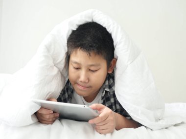 Mutlu Asya varoluş çocuk beyaz battaniye, yaşam kavramı altında tablet kullanma.