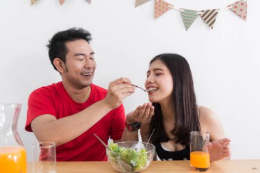 Asya çift birbirlerine salata, sevgilisi yaşam tarzı kavramı ile besleme.