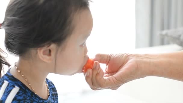 Senior Hand Voeding Gesneden Van Rijpe Papaya Aan Haar Kleinkind — Stockvideo