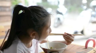 Asyalı kız yerel bir restoranda nefis .erişte yiyorlar, 