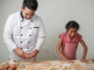 Asyalı kız şeften kruvasan işlemeyi öğreniyor. Yaşam tarzı konsepti..