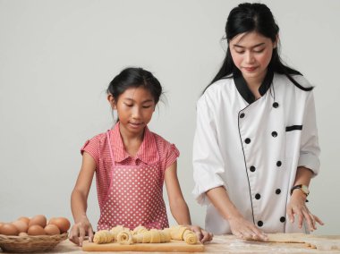 Asyalı kız şeften kruvasan işlemeyi öğreniyor. Yaşam tarzı konsepti..