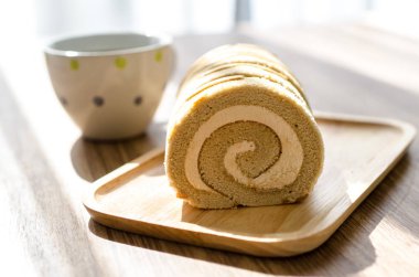 Kahve rulo pasta üzerinde ahşap masa.