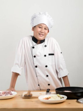 Varoluş çocukta Asya masasına onun yemek ile üniforma şef.