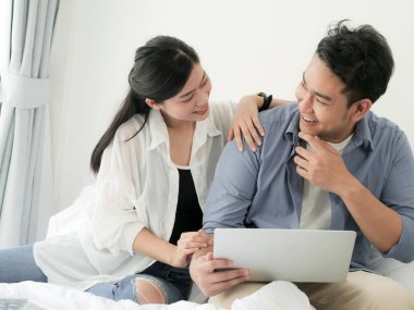 Evde, dizüstü bilgisayar kullanarak mutlu Asya Çift yaşam tarzı kavramı.