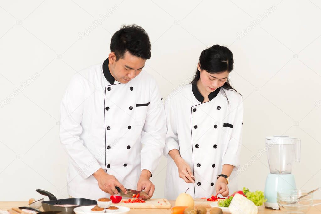 Asian chef man teaching his cook helper preparing food, work lifestyle concept.