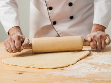 Hareket Şef eller pizza yapmak için hamur yayıyoruz bulanıklaştırma veya masada ekmek.
