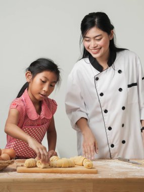 Asyalı kız şeften kruvasan işlemeyi öğreniyor. Yaşam tarzı konsepti..