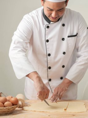 Asya Şef kesme ince hamur bir kruvasan hamur ahşap tahta üzerinde haddeleme önce eller.